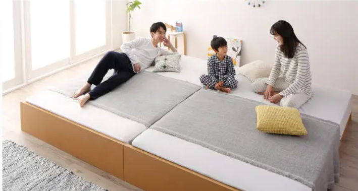 小学生の子どもと家族が一緒に寝る画像