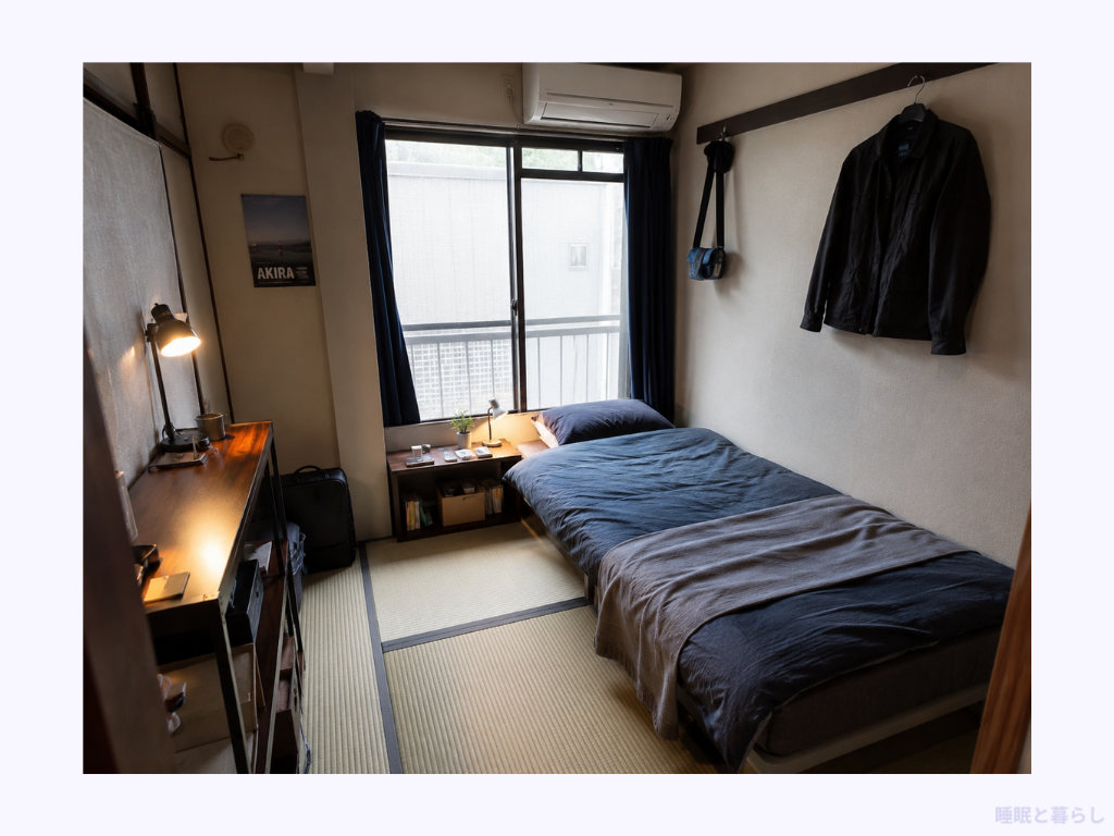 窓際にシングルベッドとデスクを配置した畳敷きの部屋