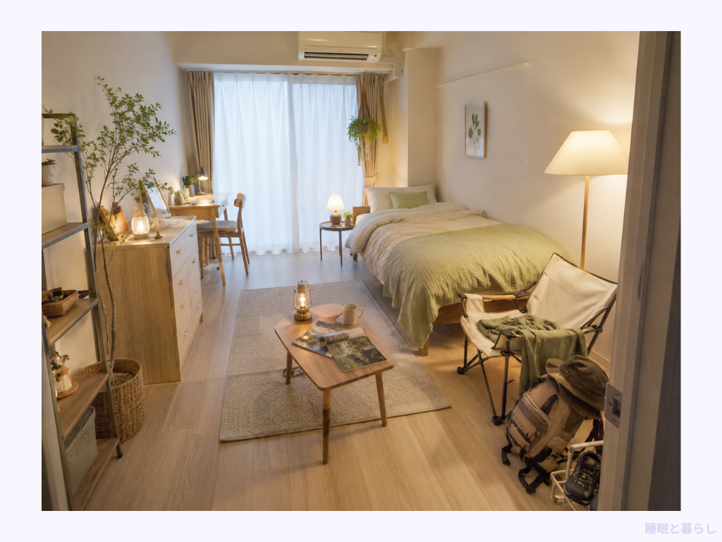 緑の寝具のシングルベッドとデスクを置いたナチュラルテイストの1人暮らしの部屋