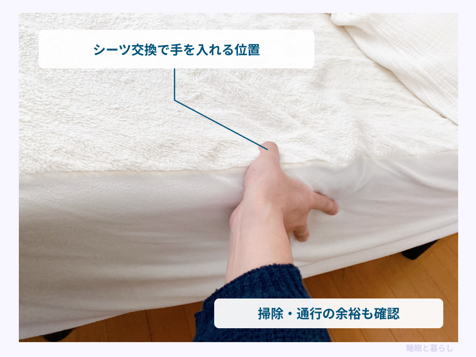 シーツ交換でベッド端に手を入れる位置と周囲の余裕を確認する写真
