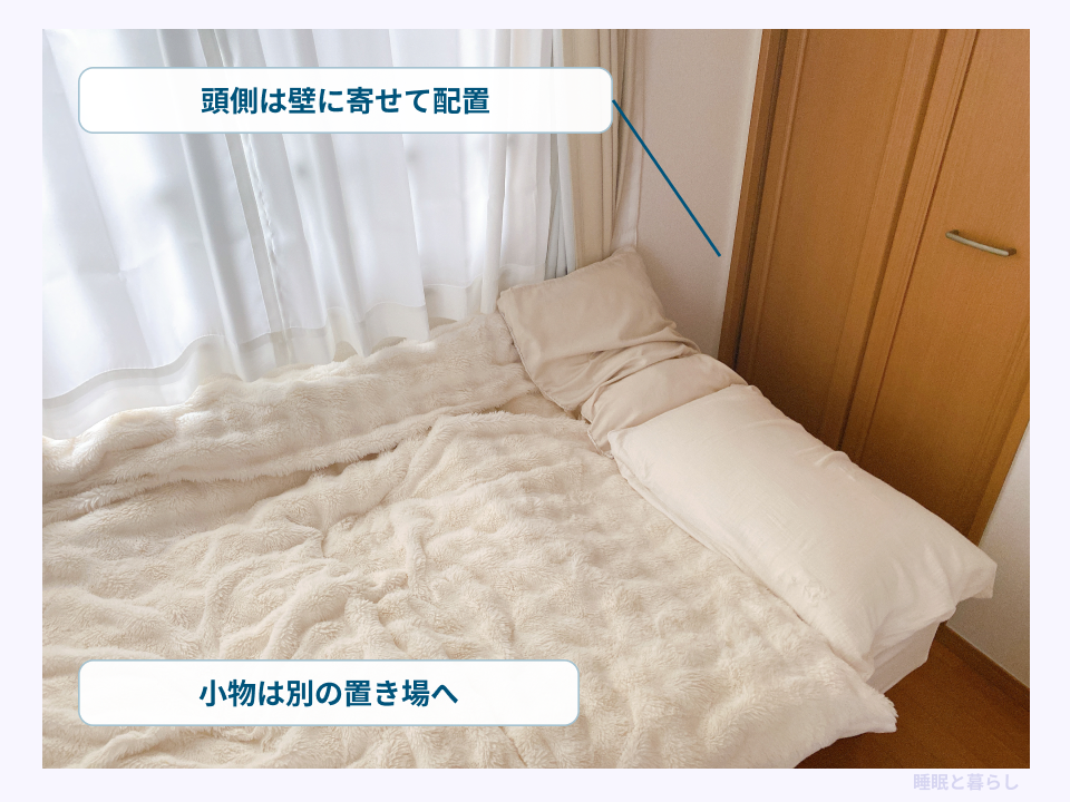 頭側を壁に寄せるヘッドレスベッドと小物の置き場を示す写真
